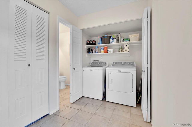 laundry room with separate washer and dryer and light tile patterned floors