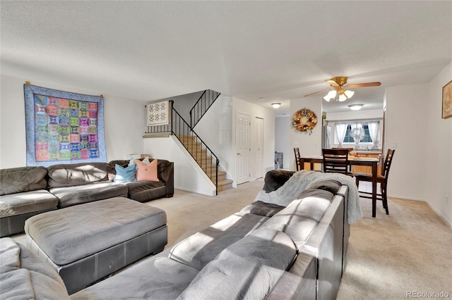 living room featuring a textured ceiling, ceiling fan, and light colored carpet