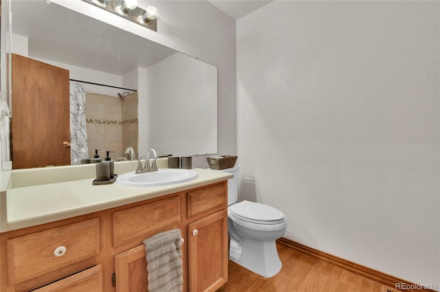 bathroom with walk in shower, vanity, hardwood / wood-style floors, and toilet