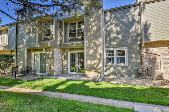 rear view of property featuring a patio and a yard