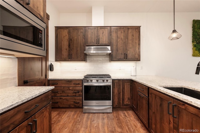 166 Hay Meadow Dr, Fraser, CO 80442 - kitchen featuring stainless steel appliances, under cabinet range hood, a sink, light stone counters, and dark wood-style flooring