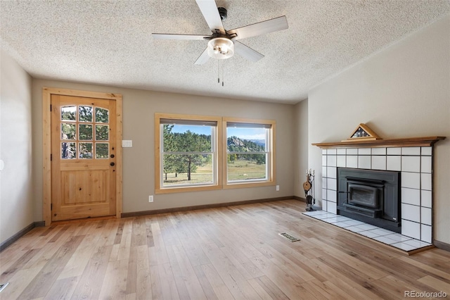 unfurnished living room featuring a textured ceiling, a healthy amount of sunlight, and light hardwood / wood-style flooring