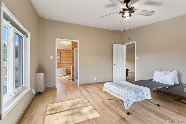 bedroom with light hardwood / wood-style flooring, ceiling fan, multiple windows, and ensuite bathroom