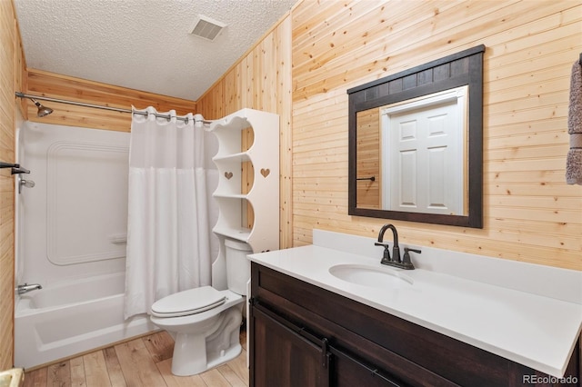 full bathroom with vanity, shower / bath combo, wood-type flooring, wooden walls, and toilet