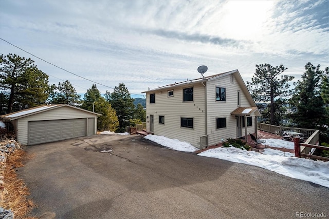 view of snow covered exterior featuring a garage and an outdoor structure