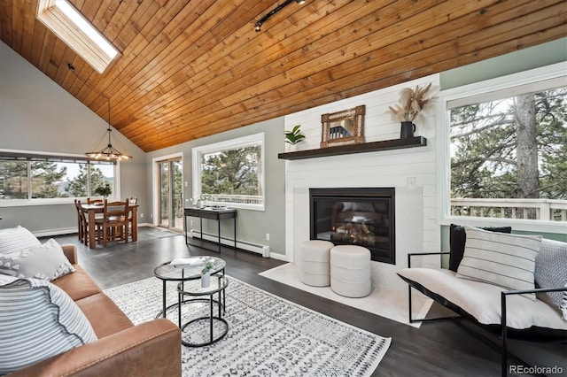 living area featuring wood finished floors, high vaulted ceiling, a skylight, a baseboard heating unit, and wooden ceiling