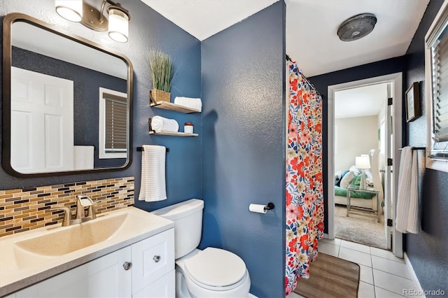 bathroom featuring tasteful backsplash, tile patterned floors, vanity, and toilet