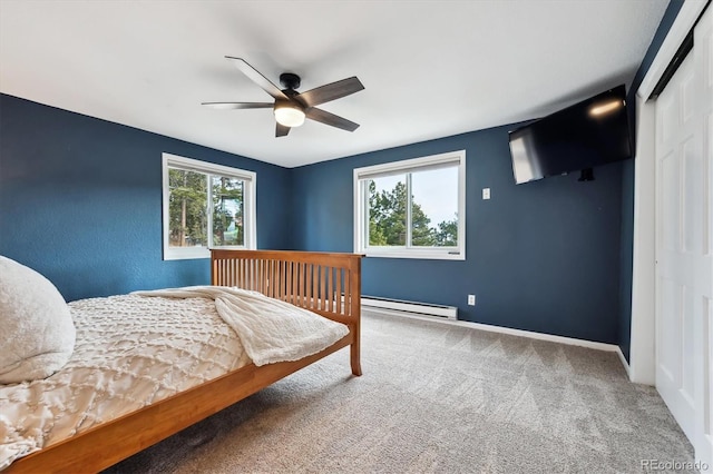 bedroom with a baseboard heating unit, carpet flooring, ceiling fan, and a closet