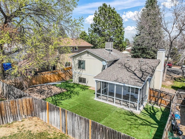 15660 E Purdue Dr, Aurora, CO 80013 - back of property with a sunroom, a shingled roof, a fenced backyard, and a lawn