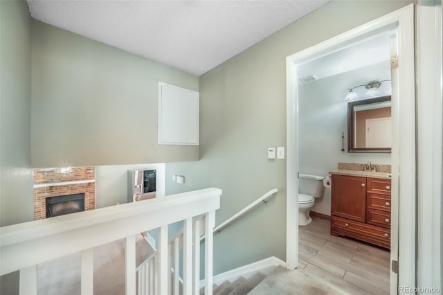 15660 E Purdue Dr, Aurora, CO 80013 - bathroom with toilet, baseboards, visible vents, wood finished floors, and a fireplace
