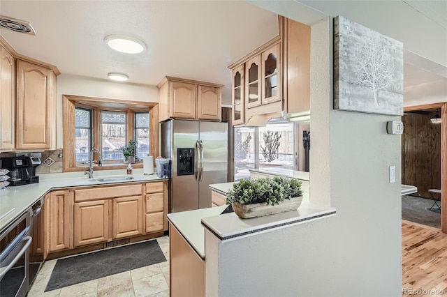 kitchen with light brown cabinets, appliances with stainless steel finishes, and a sink
