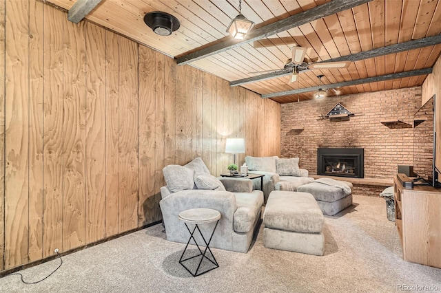 carpeted living room featuring wooden walls, ceiling fan, wood ceiling, beam ceiling, and a fireplace
