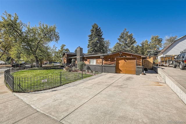 view of front of home with driveway, a front lawn, and fence