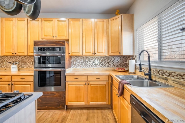 kitchen featuring butcher block counters, sink, black dishwasher, and stainless steel double oven