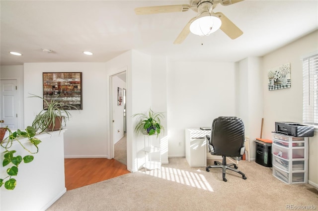 office space featuring light carpet and ceiling fan