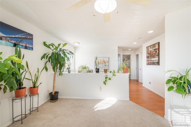 interior space with ceiling fan and light carpet