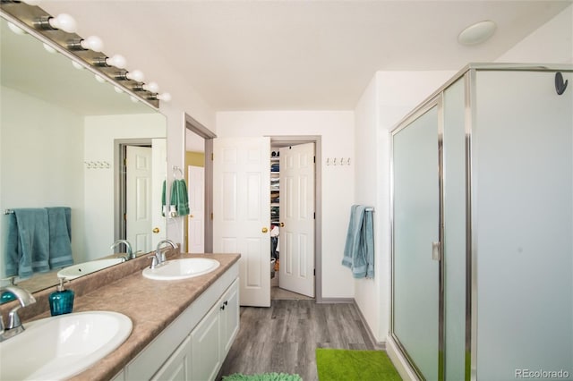 bathroom with wood-type flooring, an enclosed shower, and vanity