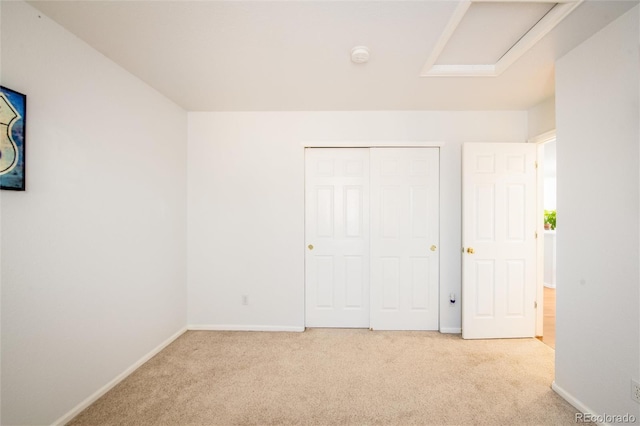 unfurnished bedroom featuring light carpet and a closet