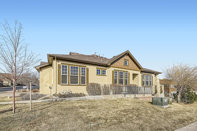 view of front facade featuring stucco siding and central AC