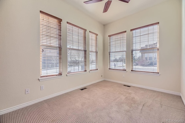 empty room with visible vents, light colored carpet, and baseboards