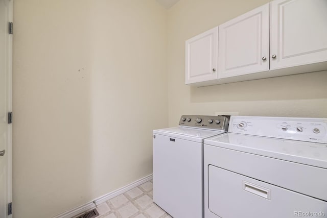 clothes washing area featuring baseboards, cabinet space, light floors, and washing machine and clothes dryer