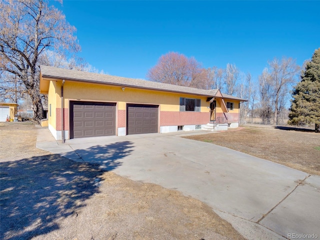 view of front of property featuring driveway, an attached garage, and stucco siding