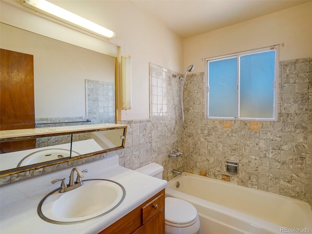 bathroom featuring washtub / shower combination, tile walls, toilet, and vanity