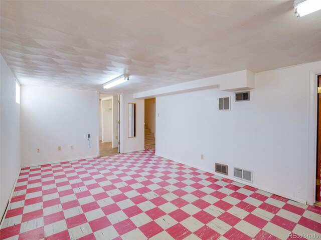 finished basement featuring light floors and visible vents