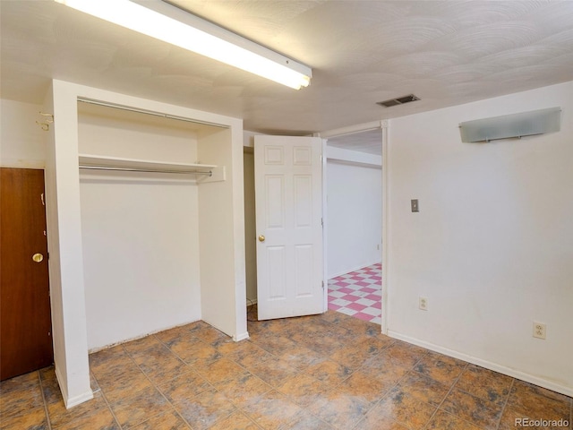 unfurnished bedroom featuring baseboards, visible vents, and a closet