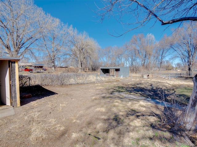 view of yard featuring a pole building, an outdoor structure, and fence