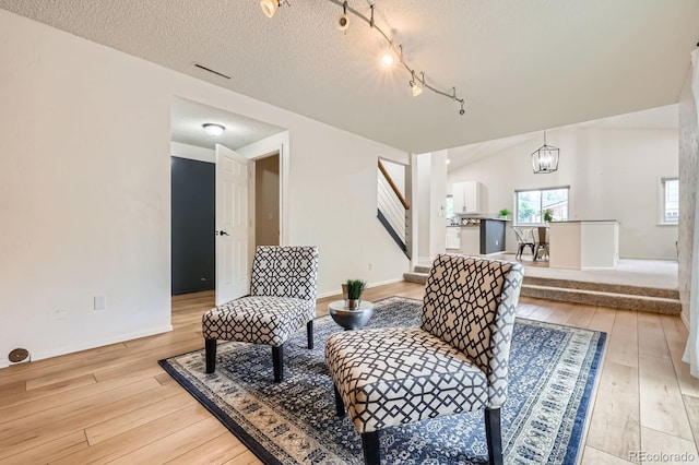 3455 Sun River Pl, Colorado Springs, CO 80920 - living area with light wood-style flooring, stairs, and a textured ceiling