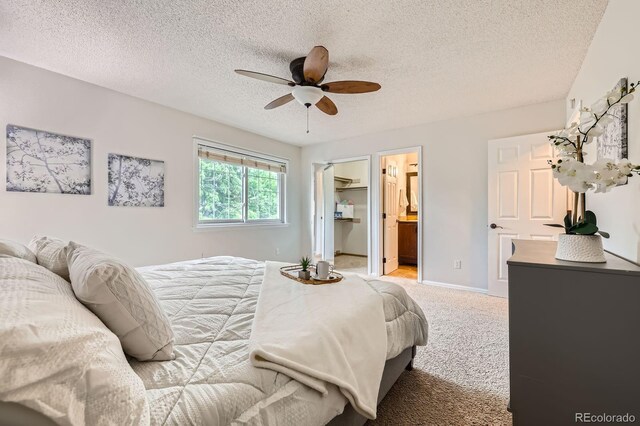 3455 Sun River Pl, Colorado Springs, CO 80920 - bedroom with carpet flooring, a walk in closet, a textured ceiling, baseboards, and ceiling fan