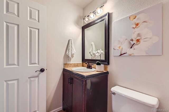 3455 Sun River Pl, Colorado Springs, CO 80920 - half bathroom with vanity, toilet, and tasteful backsplash