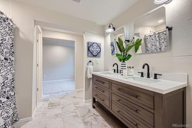 3455 Sun River Pl, Colorado Springs, CO 80920 - full bathroom with marble look tiles, double vanity, and baseboards