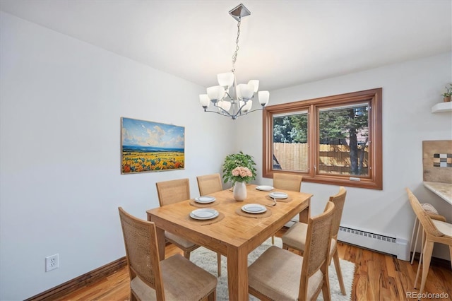 dining room featuring light hardwood / wood-style flooring, a baseboard heating unit, and a chandelier