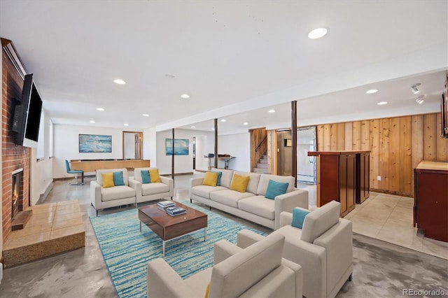 living room featuring pool table, a brick fireplace, and wood walls