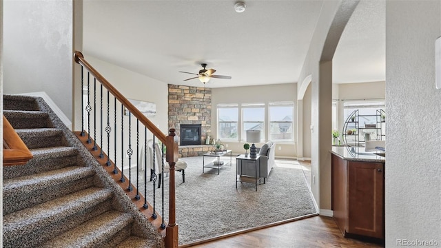 8308 Needle Drop Ct, Colorado Springs, CO 80908 - stairs featuring a ceiling fan, wood finished floors, healthy amount of natural light, arched walkways, and a textured wall