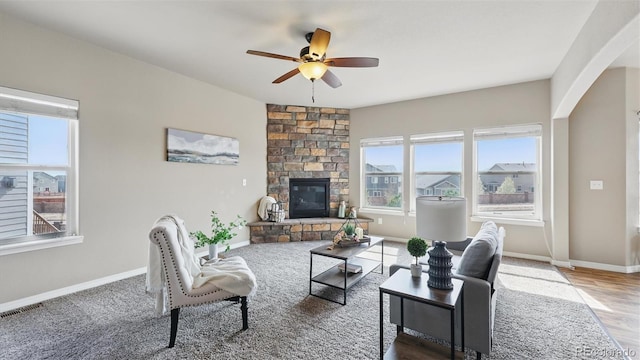 8308 Needle Drop Ct, Colorado Springs, CO 80908 - living area with healthy amount of natural light, a ceiling fan, a fireplace, and arched walkways