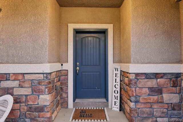8308 Needle Drop Ct, Colorado Springs, CO 80908 - doorway to property featuring stucco siding and stone siding