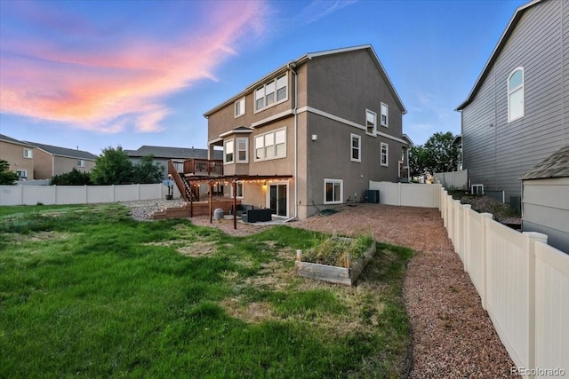 8308 Needle Drop Ct, Colorado Springs, CO 80908 - back of house featuring a fenced backyard, stucco siding, a vegetable garden, and outdoor lounge area