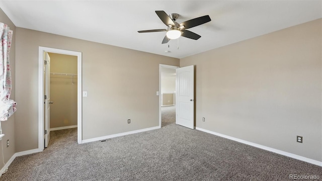 8308 Needle Drop Ct, Colorado Springs, CO 80908 - unfurnished bedroom with carpet, a spacious closet, ceiling fan, and a closet