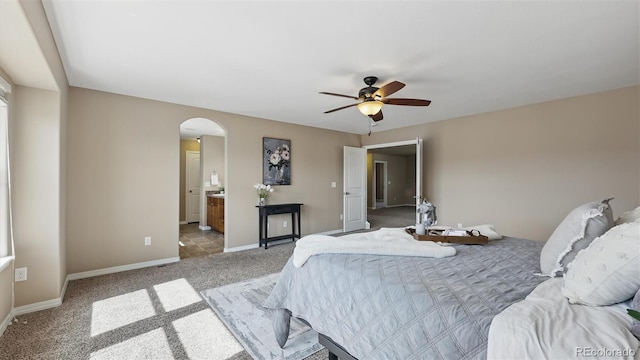 8308 Needle Drop Ct, Colorado Springs, CO 80908 - bedroom with arched walkways, light colored carpet, connected bathroom, and ceiling fan