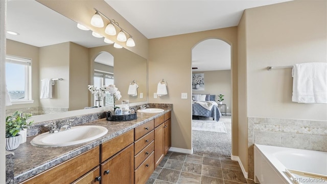 8308 Needle Drop Ct, Colorado Springs, CO 80908 - ensuite bathroom with double vanity, healthy amount of natural light, a garden tub, and stone finish floors