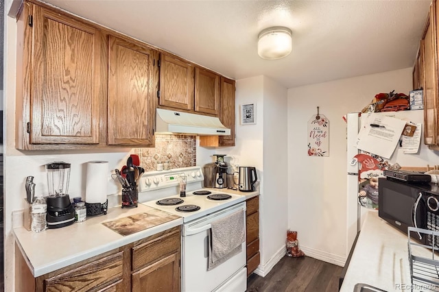 kitchen featuring white electric stove, light countertops, black microwave, and under cabinet range hood