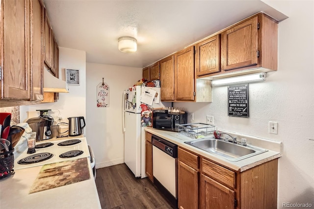 kitchen with brown cabinets, white appliances, light countertops, and a sink