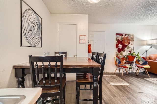 dining room featuring a textured ceiling and wood finished floors