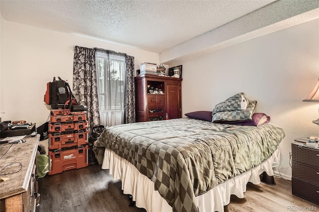 bedroom featuring dark wood-type flooring and a textured ceiling