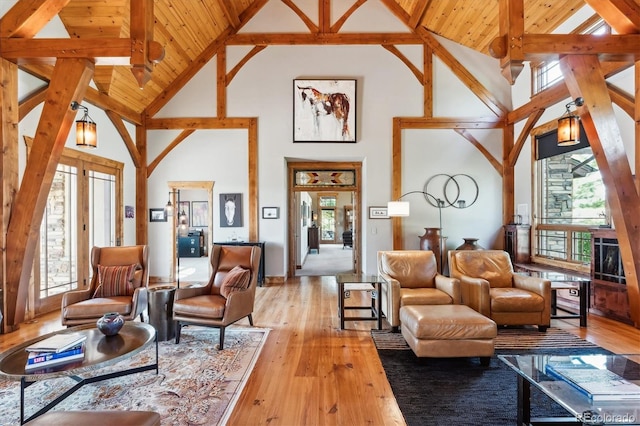 living room with high vaulted ceiling, light hardwood / wood-style floors, wooden ceiling, french doors, and beamed ceiling