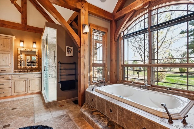 bathroom featuring lofted ceiling, plenty of natural light, and separate shower and tub