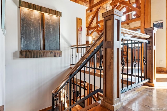 stairs featuring wood ceiling, hardwood / wood-style flooring, and lofted ceiling with beams